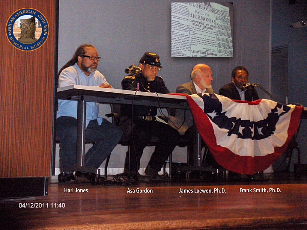 Hari Jones, Asa Gordon, James Loewen,, Ph.D., and. Frank. Smith, Ph.D. are seated on stage at a table